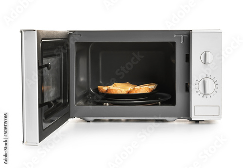 Plate with tasty sandwiches in microwave oven on white background