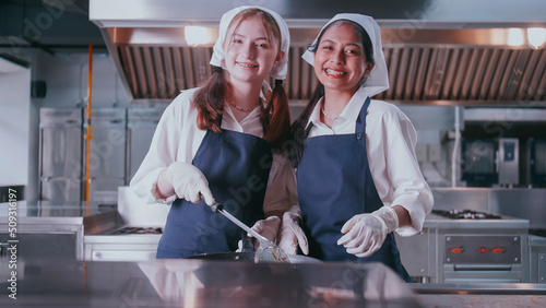 Group of schoolgirls having fun learning to cook. Female students in a cooking class.