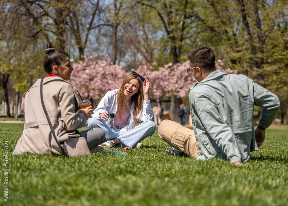 Carefree students spending time in park and enjoying in beautiful spring time Carefree students spending time in park and enjoying in beautiful spring time
