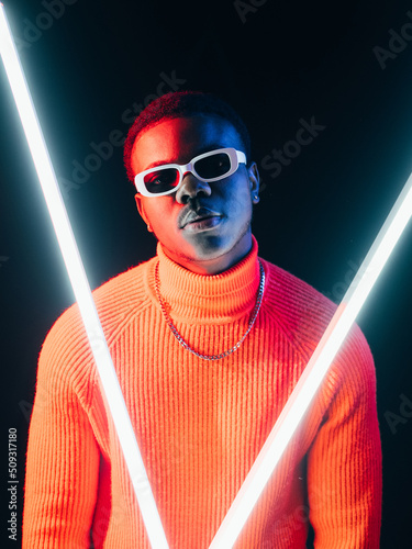 Futuristic man. Cyberpunk fashion. Retro wave style. Confident stylish dude in bright colorful neon light LED lamps on dark background. photo