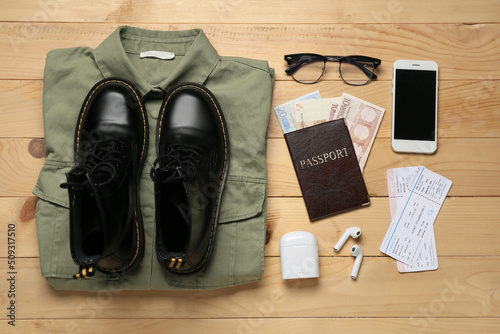 Guide's belongings with mobile phone and tickets on wooden background