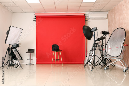 Lighting equipment, chair and cyclorama in modern photo studio