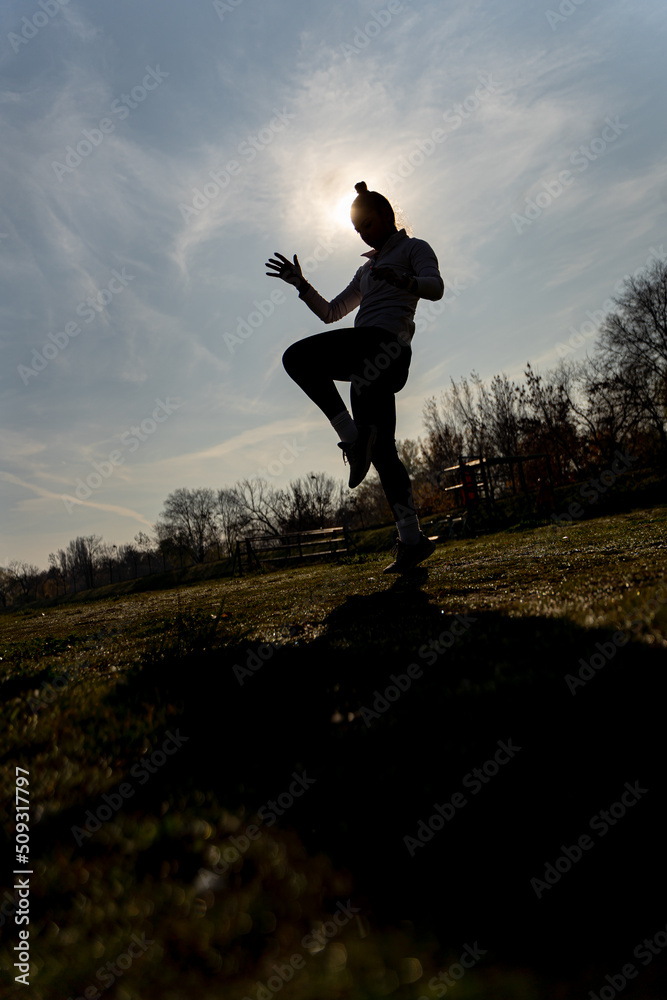 Exercising kickbox, silhouette. Low angle Exercising kickbox, silhouette. Low angle