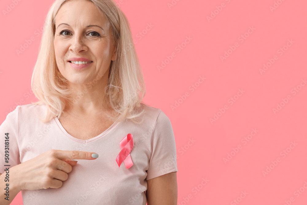 Mature woman with pink ribbon on color background. Breast cancer awareness concept Mature woman with pink ribbon on color background. Breast cancer awareness concept