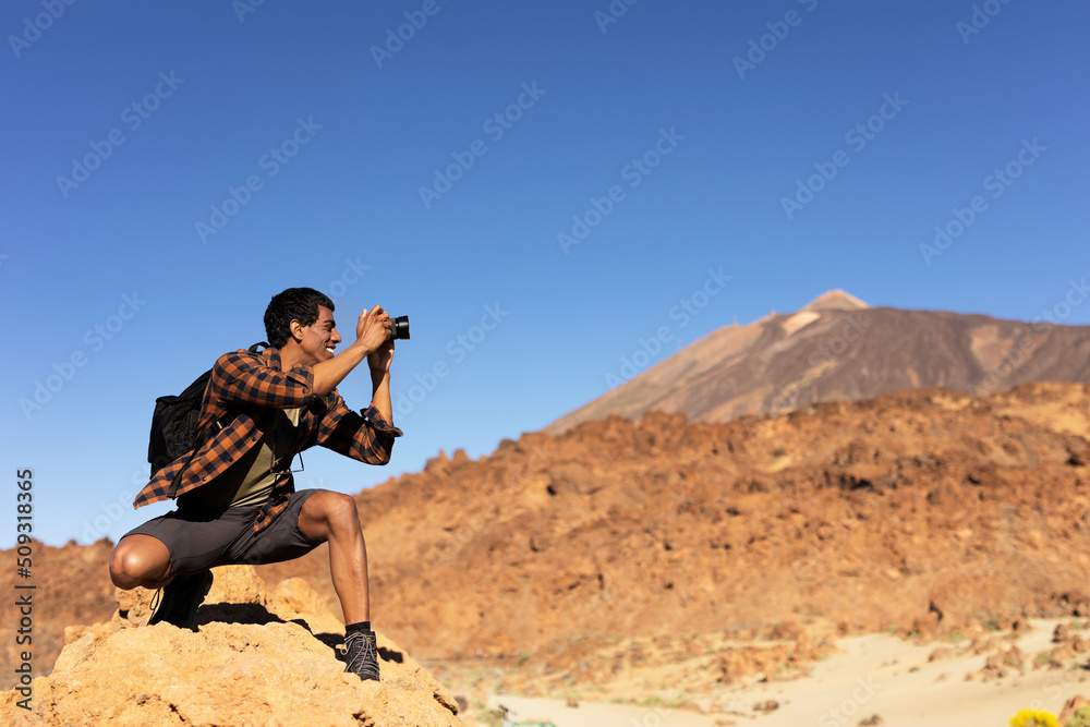 Young man taking pictures on a road trip. Man making memories on the mountain