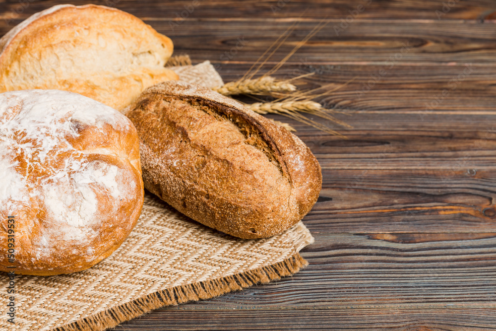 Homemade natural breads. Different kinds of fresh bread as background, perspective view with copy space Homemade natural breads. Different kinds of fresh bread as background, perspective view with copy space