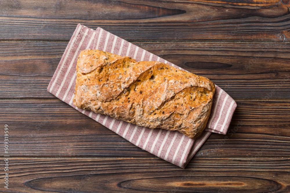 Fresh loaves of bread with wheat and gluten on a colored table. bread on napkin on rustic background, fresh bread top view Fresh loaves of bread with wheat and gluten on a colored table. bread on napkin on rustic background, fresh bread top view