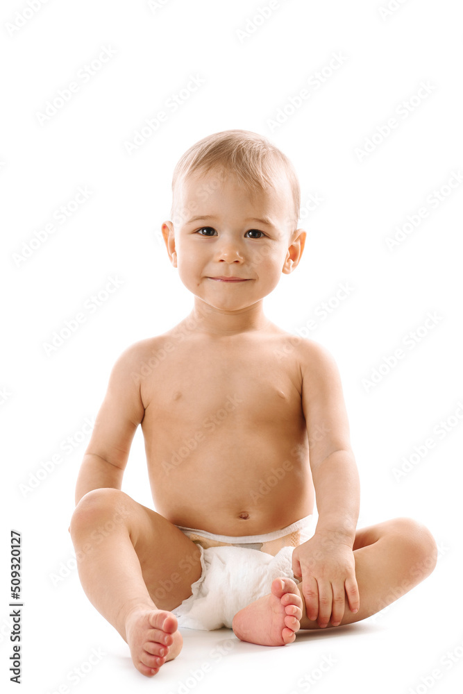 Curious healthy little boy in diaper sitting and smiling. Curious healthy little boy in diaper sitting and smiling.