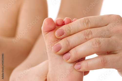 Mother massaging little child s feet and soles.