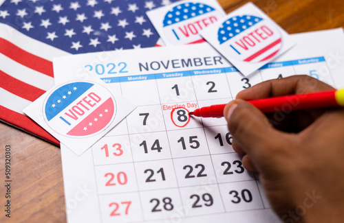 close up shot of hands marking November 8 as reminder for polling in 2022 US or american mediterm election.