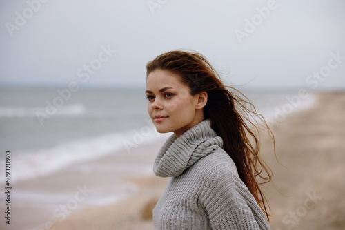 woman red hair in a sweater by the ocean Relaxation concept