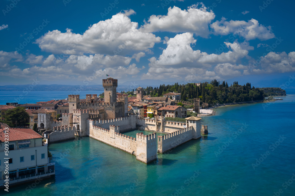Italian castles Scaligero on the water. Town of Sirmione entrance walls view, Lago di Garda, Lombardy region of Italy drone view. Aerial view of Sirmione, an ancient village on southern Garda Lake.