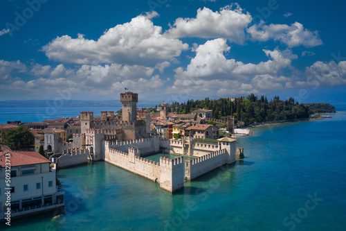 Italian castles Scaligero on the water. Town of Sirmione entrance walls view, Lago di Garda, Lombardy region of Italy drone view. Aerial view of Sirmione, an ancient village on southern Garda Lake.