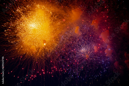 Bright orange and blue fireworks on the background of the night sky. High quality photo