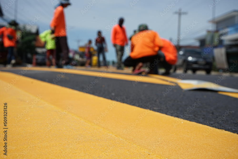 Blurred image, paved road and yellow traffic markings Blurred image, paved road and yellow traffic markings