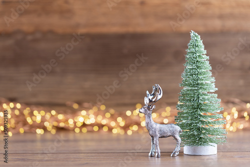 Colorful Christmas tree on wooden, bokeh background.