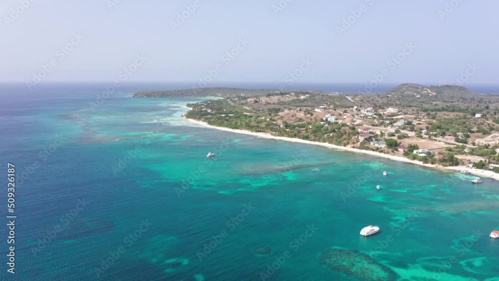 Drone flying over Caribbean waters of Playa Ensenada beach in Dominican Republic. Sky for copy space. Aerial forward Drone flying over Caribbean waters of Playa Ensenada beach in Dominican Republic. Sky for copy space. Aerial forward