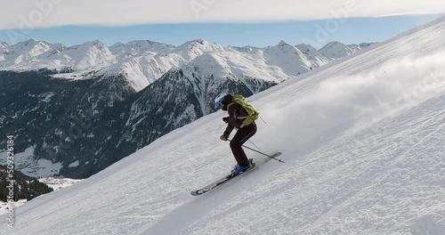 Cinematic downhill skiing in beautiful winter mountain landscape with high speed and fresh snow. Sporty skiing with high speed on a steep ski slope in the tyrolean mountains with great light 4K. photo