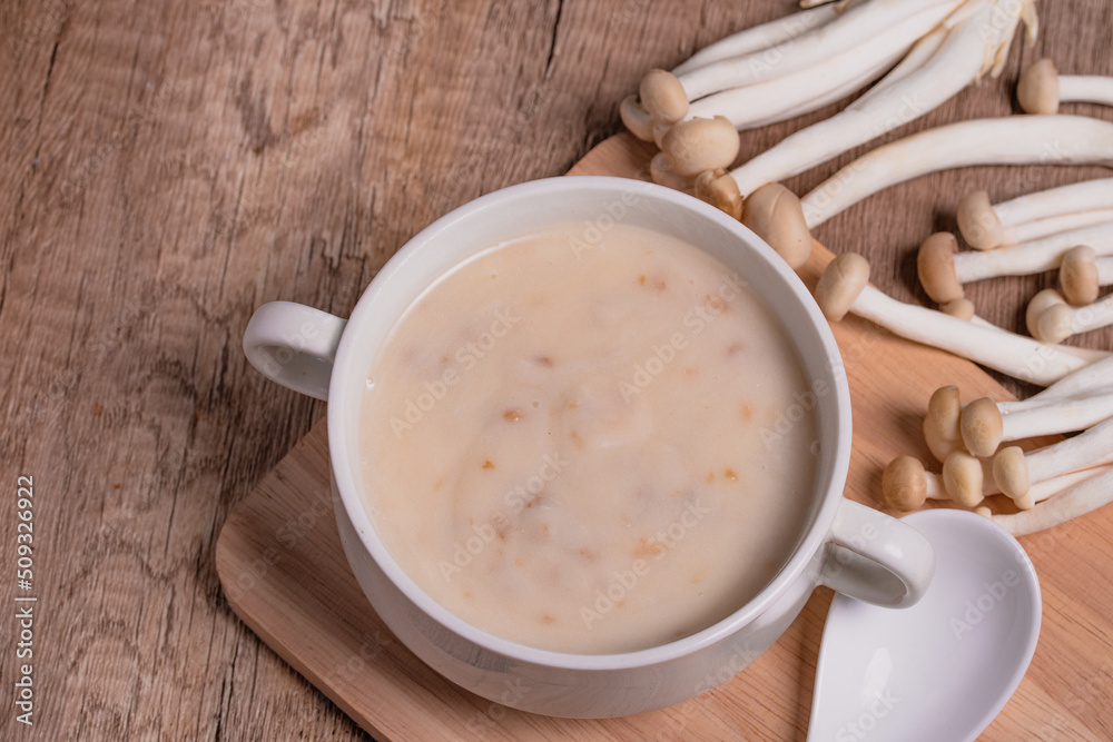 Mushroom cream soup in a white cup on the wooden floor. Mushroom cream soup in a white cup on the wooden floor.