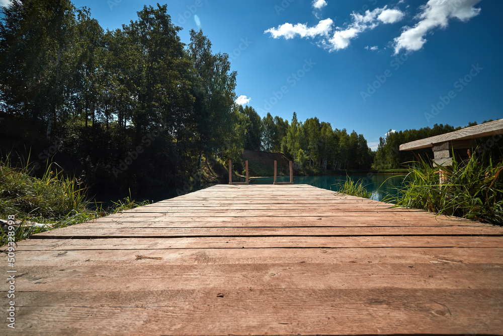 Wooden jetty on lake in the sunny summer day.