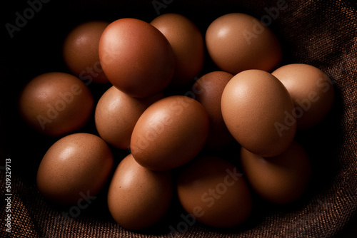 Red hen eggs on dark rustic table, organic food ingredients 