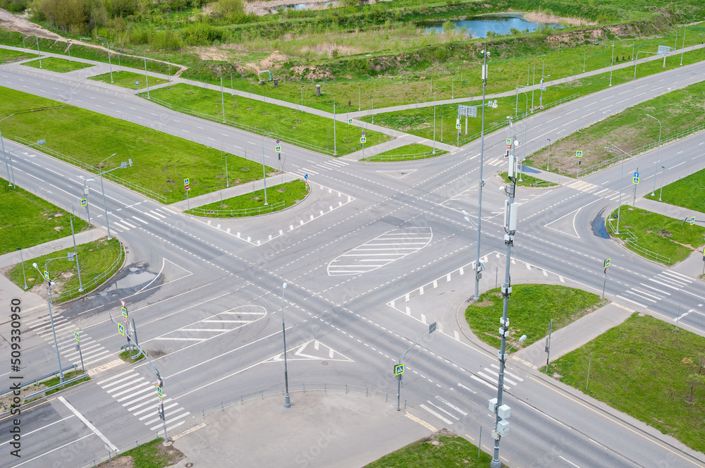 View above of empty street intersection, with crosswalk markings and traffic signal lights