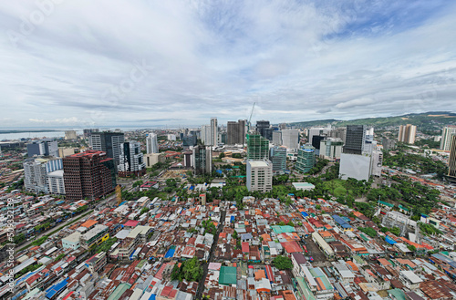 Cebu City, Philippines - Contrast of incomes, modern office buildings loom over a crowded poorer district. photo