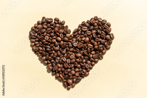 Coffee background. Coffee grains in the form of a heart. Coffee shop advertisement. Place for text. International coffee day.