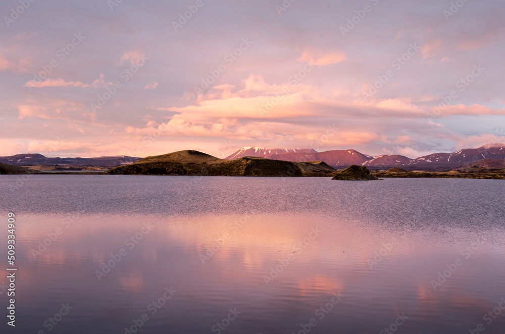 Landscape with mountains, hills and craters under a spectacular sky reflecting in lake Myvatn, Iceland