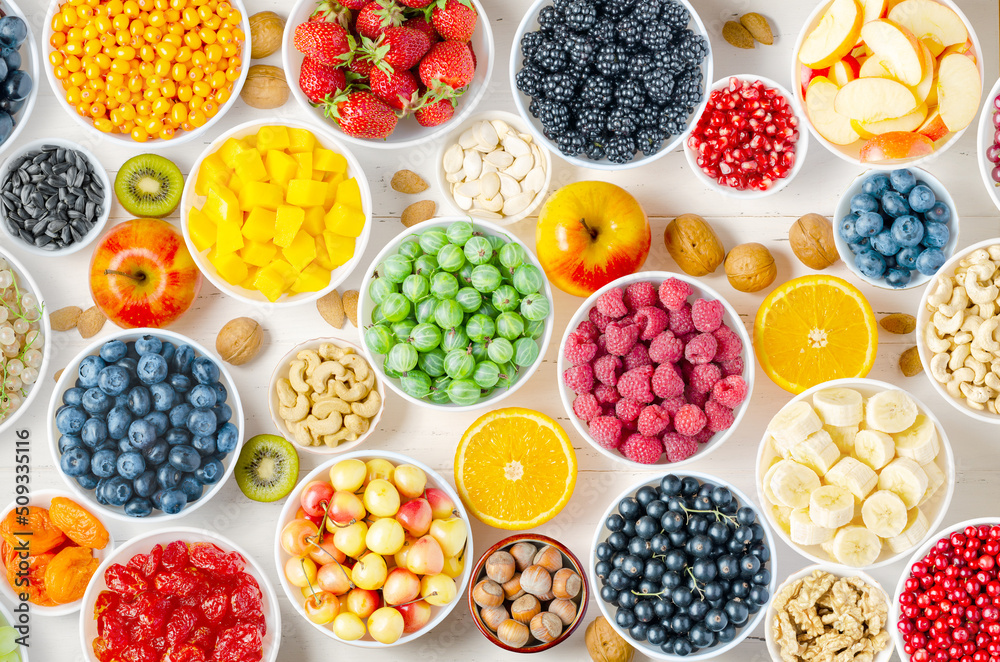 Berries, fruits and nuts on a white wooden background. Vegetarian food. Berries, fruits and nuts on a white wooden background. Vegetarian food.
