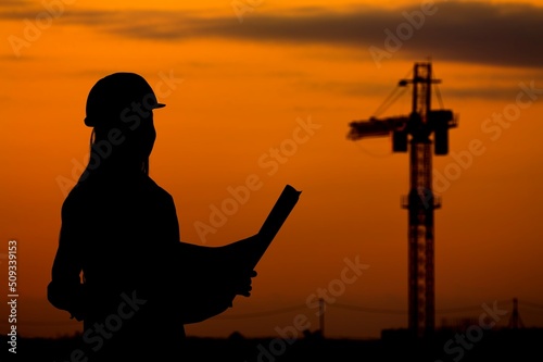 Silhouette of Engineer under inspection. Engineer man in waistcoats and hardhats and with documents.