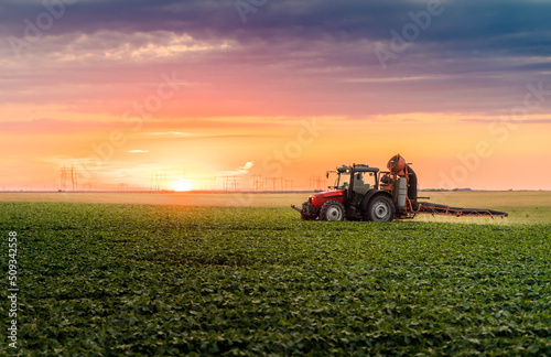 Tractor spraying soybean crops field