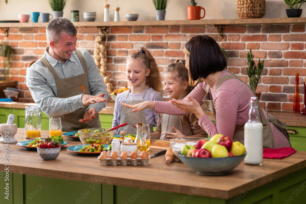 At the kitchen island very luminous in front of the camera beautiful and charismatic family all together have a healthy breakfast in the morning before they go to school and work
