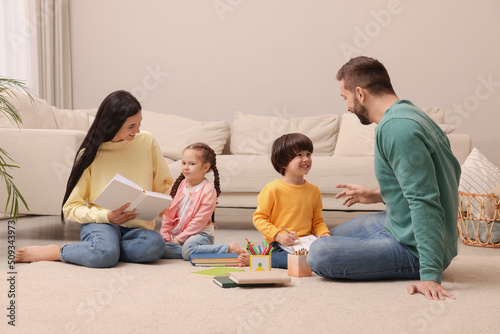 Happy family spending time together on floor in living room