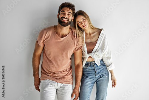 Portrait of heterosexual couple looking at camera and smiling isolated on gray background