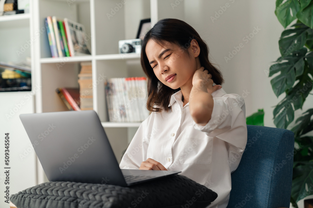 Tired young woman with neck pain because using the computer and working for a long time at home. Tired young woman with neck pain because using the computer and working for a long time at home.