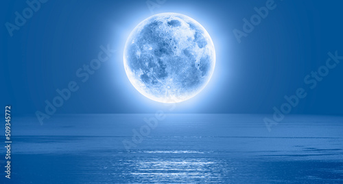 Full moon over the sea at sunset  Elements of this image furnished by NASA 