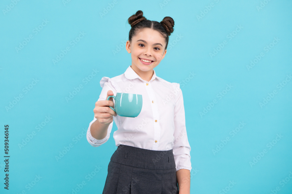Teenage girl with cup of cappuccino coffee or tea. Child with cup on blue background, morning drink beverage.