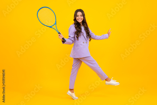 Tennis player hold tennis racket over isolated yellow studio background. Sport and fitness for kids. Fashion and sport concept. Teenager child with tennis racquet. © Olena