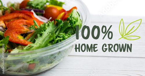 Image of 100 percent home grown text in green over bowl of fresh salad on white boards