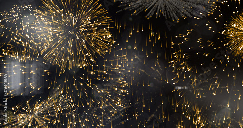 Image of exploding gold fireworks scrolling on black background