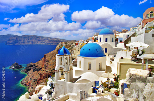 Iconic view with blue domes and caldera of most beautiful island - Santorini, Oia village, Cyclades . Greece