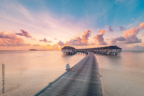 Amazing tropical sunset panorama at Maldives islands. Luxury resort villas seascape with soft led lights colorful dream sky. Fantastic summer holiday concept, vacation landscape sunrise sea horizon