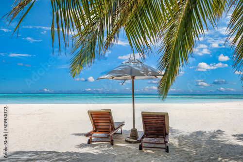 Beautiful tropical island  two chairs  umbrella under palm tree leaves  paradise sea sand sky. Summer travel landscape  vacation beach scenic  idyllic exotic nature closeup of recreation  relaxation. 