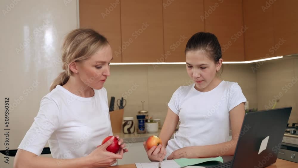 Caring mom babysitter teacher helping kid daughter with homework, family education together. Caring mom babysitter teacher helping kid daughter with homework, family education together.