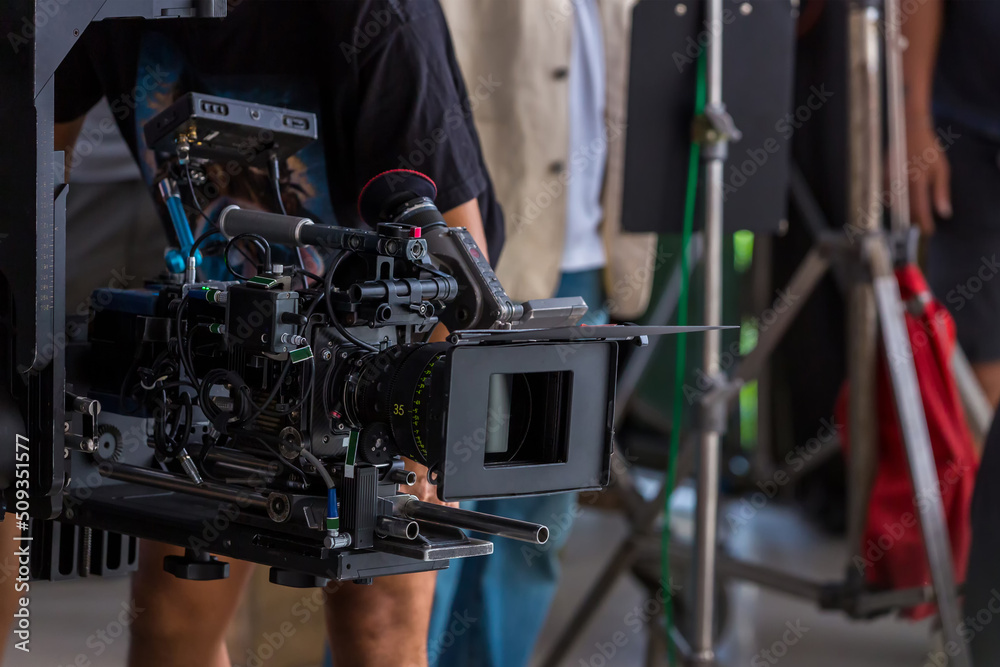 Obraz premium Movie shooting or video production and film crew team with camera equipment. Video camera operator working with equipment. Director of photography with a camera in his hands on the set 