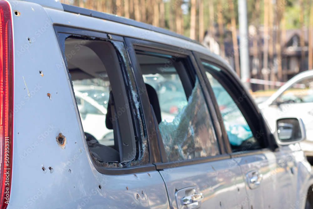Car riddled with bullets. War of Russia against Ukraine. A car of civilians shot by the Russian military during the evacuation of women and children. Traces of bullets and fragments of shells. Car riddled with bullets. War of Russia against Ukraine. A car of civilians shot by the Russian military during the evacuation of women and children. Traces of bullets and fragments of shells.