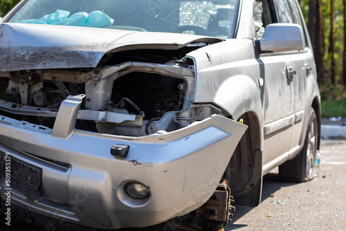 Broken headlights as a result of a collision. Broken gray car after an accident. Car accident concept. Damaged emergency headlight, hood and bumper. Damage to the car body after the accident.