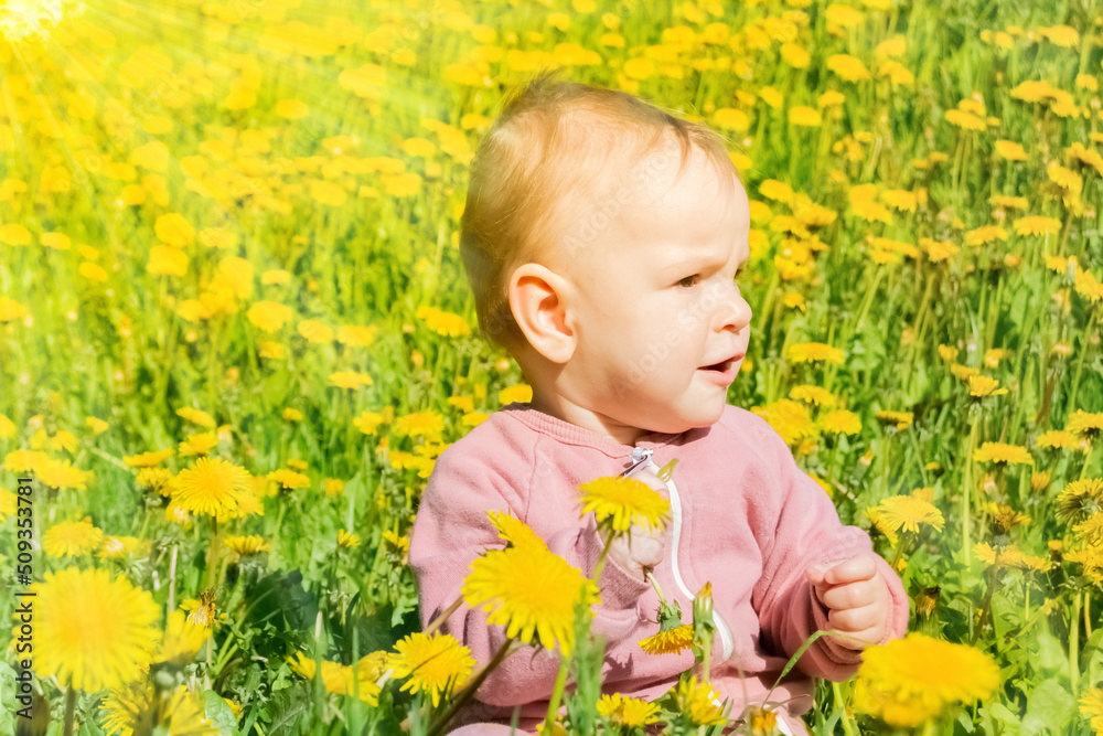 child in bright yellow dandelions looks away
