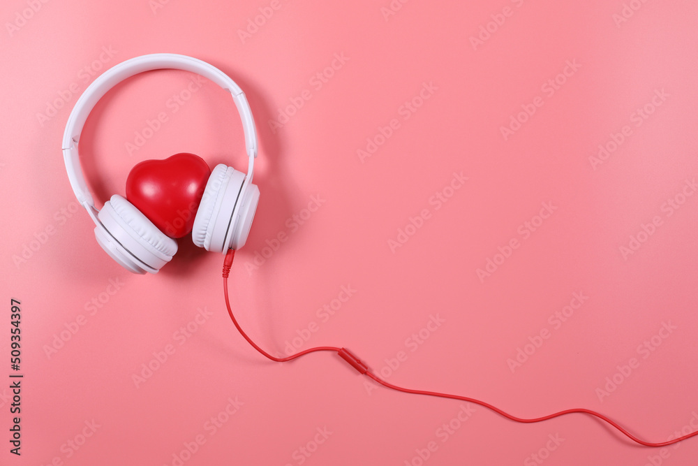 White headphone with red heart isolated on pink background, flat lay photography have copy space. White headphone with red heart isolated on pink background, flat lay photography have copy space.